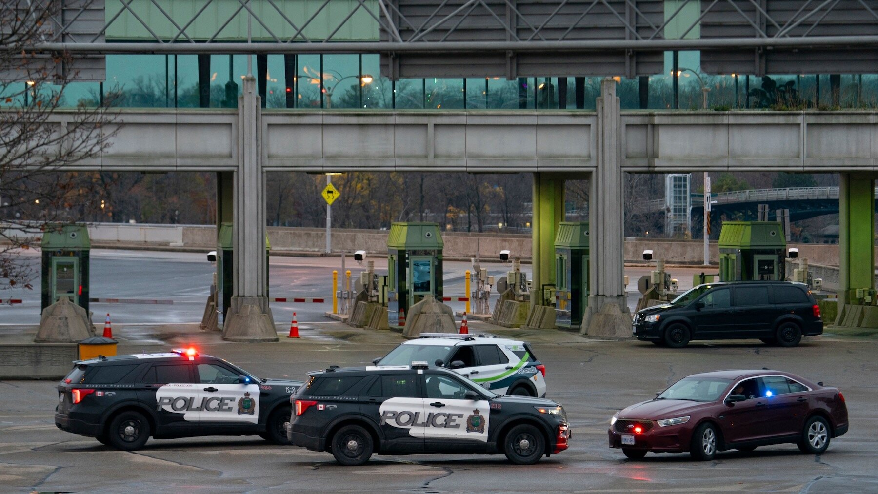 Canadian police cars are seen near the Rainbow Bridge border crossing into the US in Niagara Falls, Ontario, after a car exploded at a US-Canada checkpoint on November 22, 2023. US terrorism investigators deployed Wednesday after a car erupted into a fireball at a US-Canada checkpoint, triggering border closures on one of the busiest travel days in the American holiday calendar. Two people were killed in the blast, according to US media citing authorities, although their identities were not yet public.